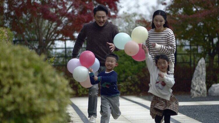 幸福的一家三口放飞气球奔跑