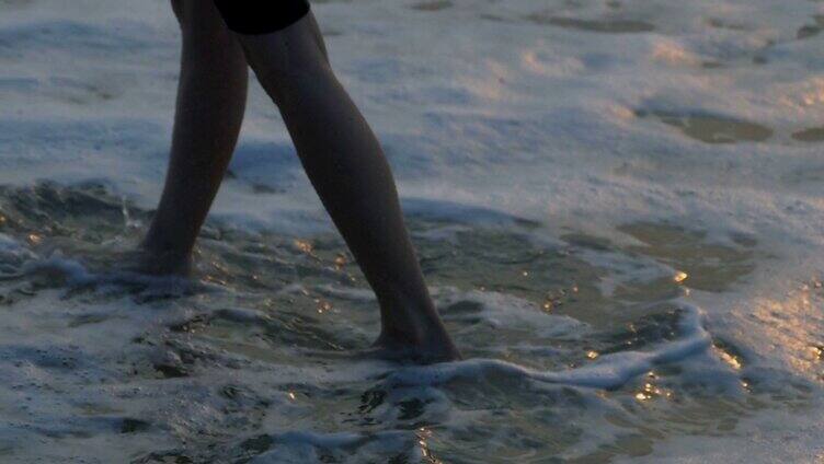 傍晚沙滩上赤脚行走的女人