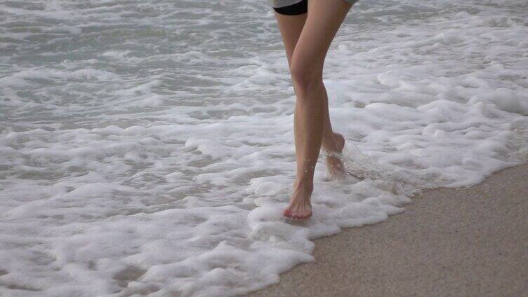 海滩上赤脚奔跑的女人慢镜头