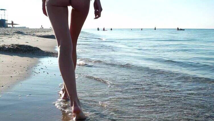 低角度拍摄女子光脚在海边漫步