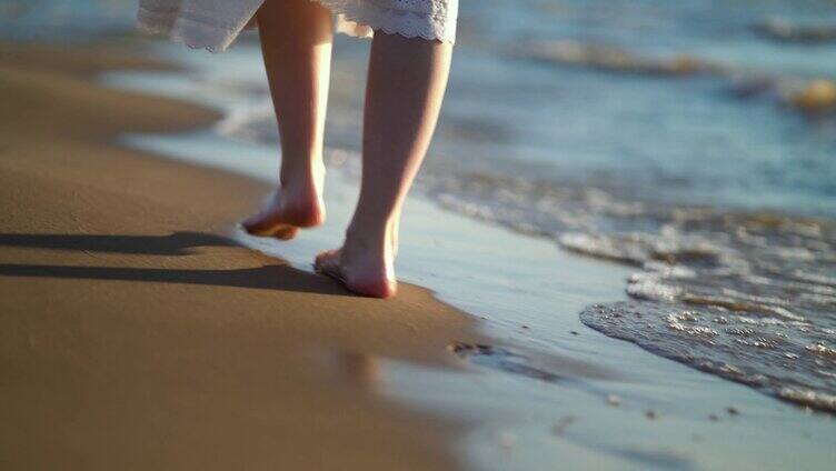 海边沙滩上赤脚走路的女人