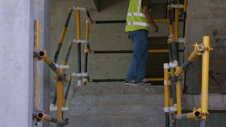 建筑工人在工地走路上楼梯