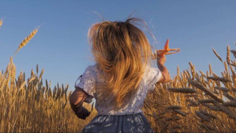 小女孩在田野玩玩具飞机