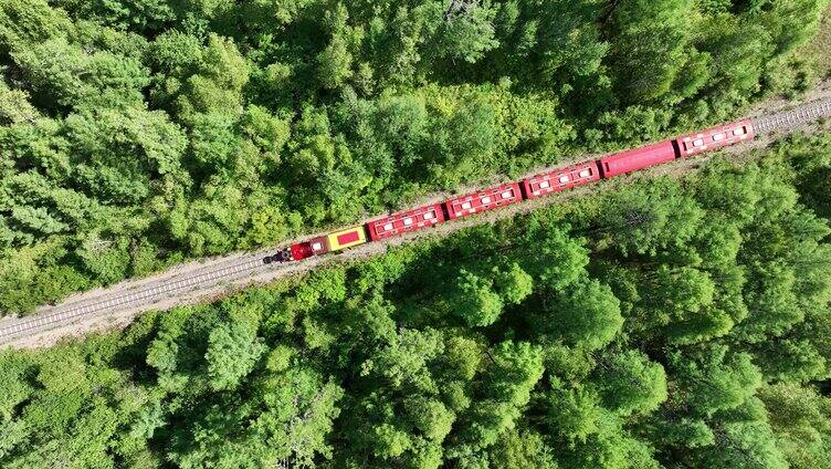航拍行驶在绿色林海中的小火车