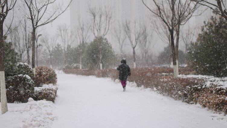大雪纷飞中孤独行走的人背影