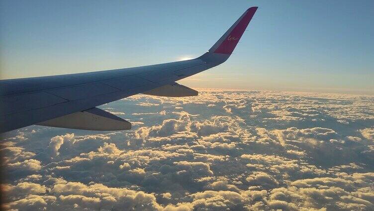飞机窗外的景色，金光灿烂的高空云海。