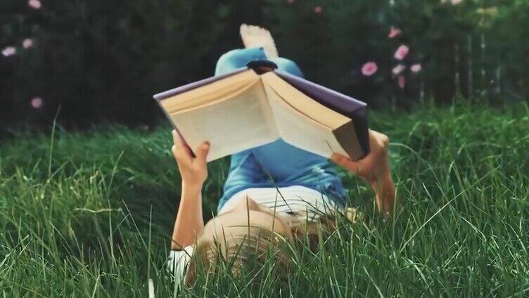 女孩躺在草地上看书