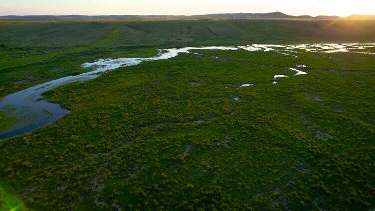 夕阳西下辽阔草原上蜿蜒的溪流4k航拍视频