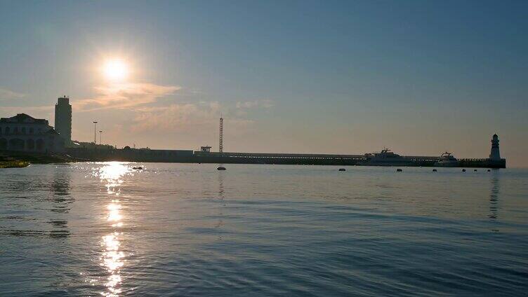 海边清晨日出海面与灯塔