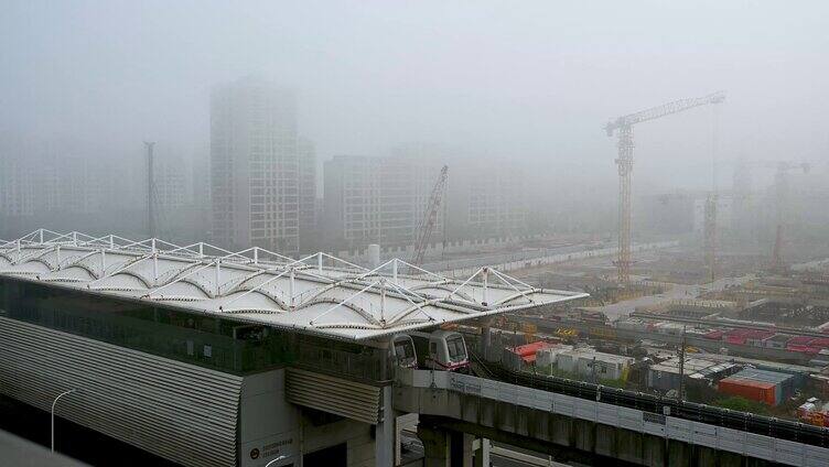晨雾下地铁站与建筑工地塔吊