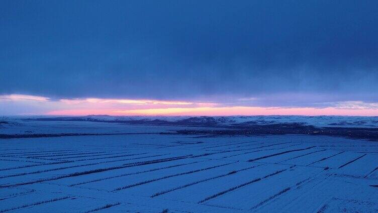 航拍浓郁夕阳下的垦区雪原