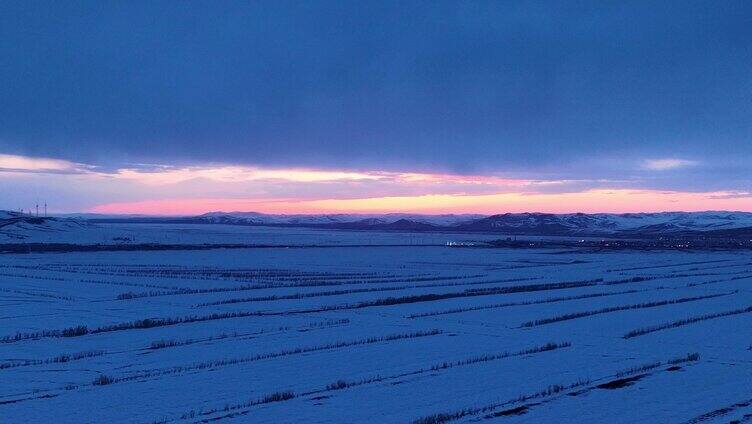 航拍浓郁夕阳下的垦区雪原