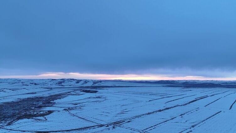 航拍浓郁夕阳下的垦区雪原