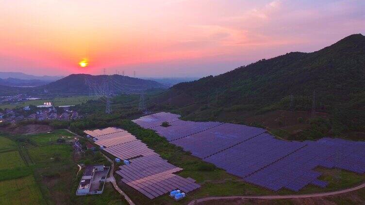 山坡航拍夕阳下新能源太阳能光伏发电站