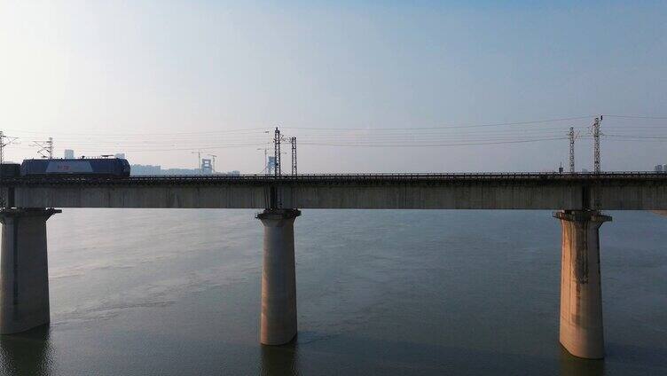 货运火车飞驰过城市跨江大桥
