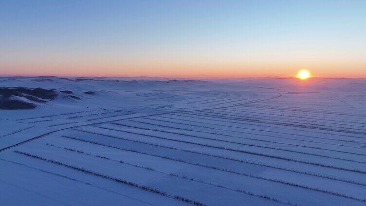 航拍浓郁夕阳下的垦区雪原