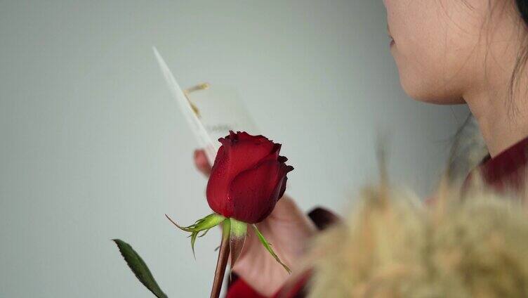 情人节美女拿着玫瑰花阅读卡片升格视频