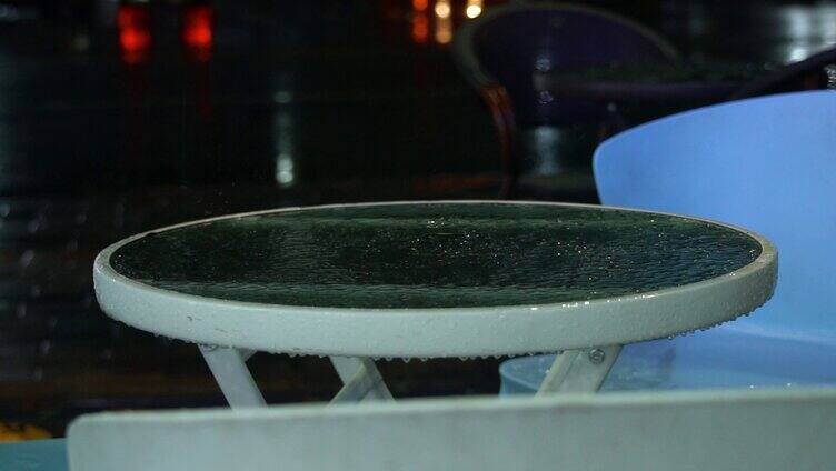 实拍夜晚雨滴滴在桌面溅起水花特写视频