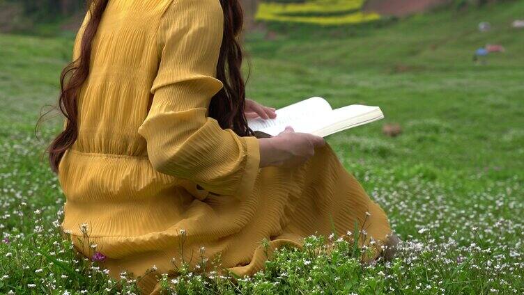 4K少女坐在草坪上看书阅读翻书实拍视频