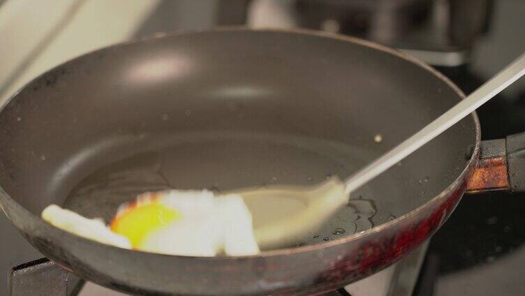 4K用锅铲翻动锅里的煎鸡蛋实拍视频