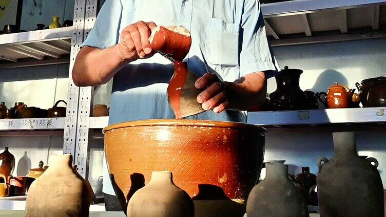 制陶工匠用传统工艺为陶瓷白坯上釉