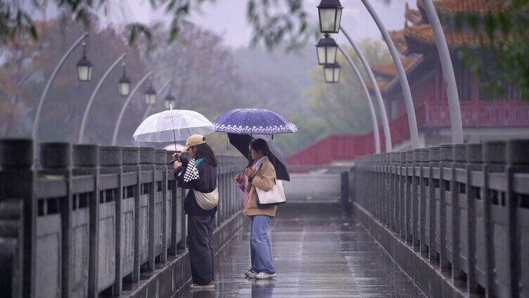 几个女孩走在古色古香的石桥上拍照