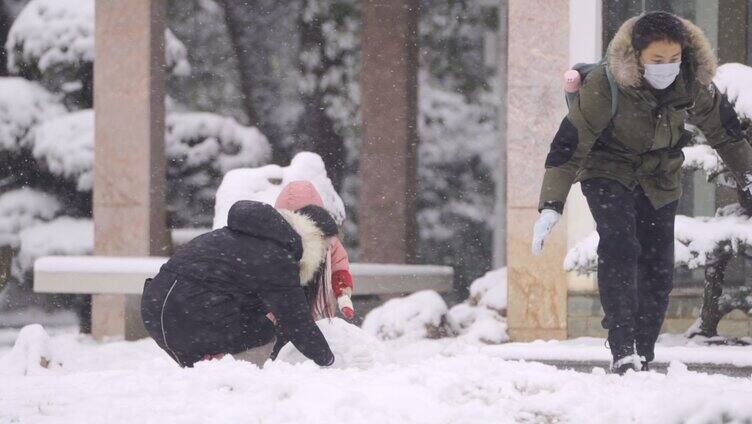 幸福的一家三口在堆雪人