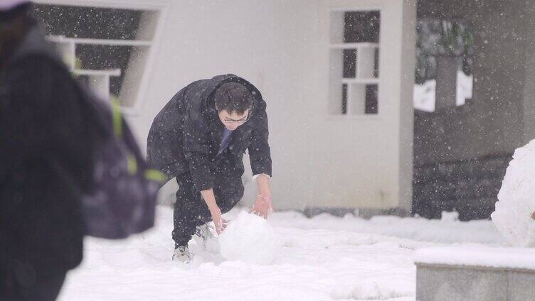 情侣在院子里滚雪球