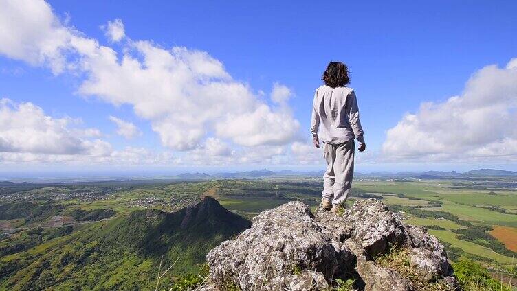 男人登上山顶，看远方拥抱自然