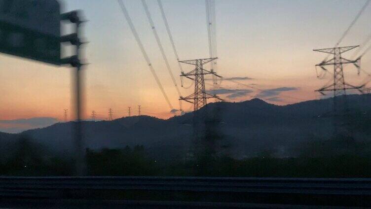 高速公路上拍摄的山间夕阳电线杆