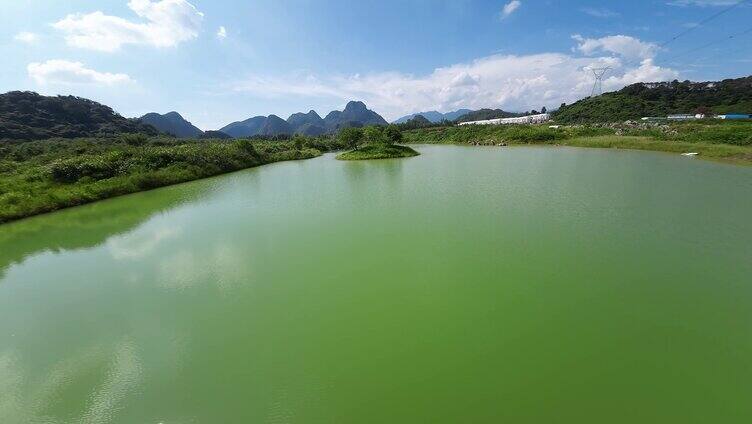 FPV航拍蓝天白云下的绿水湖泊