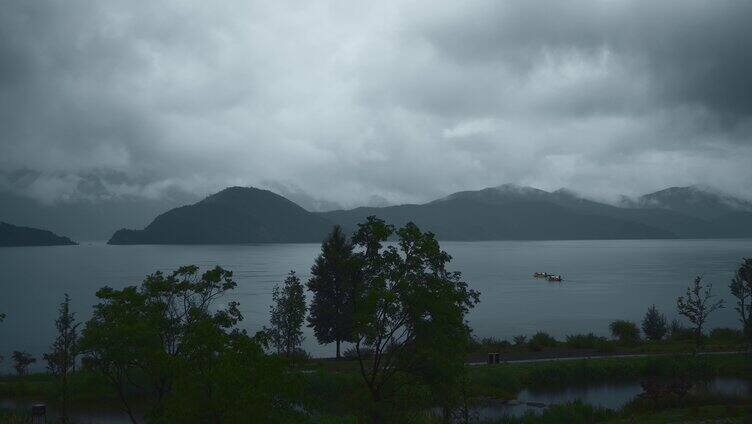 云南高原湖泊泸沽湖阴雨天乌云山脉湿地公园