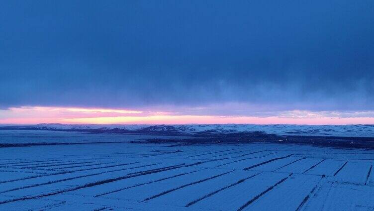 航拍浓郁夕阳下的垦区雪原