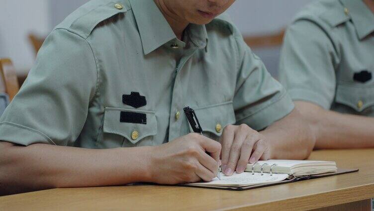 部队开会认真记录学习 做笔记的部队军人