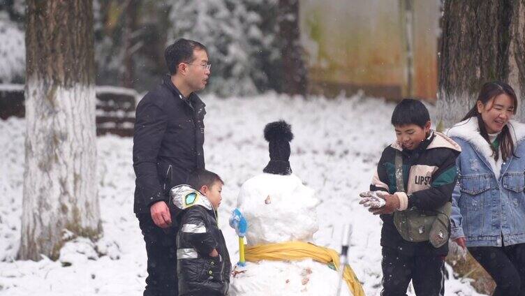 幸福一家四口和雪人拍照合影