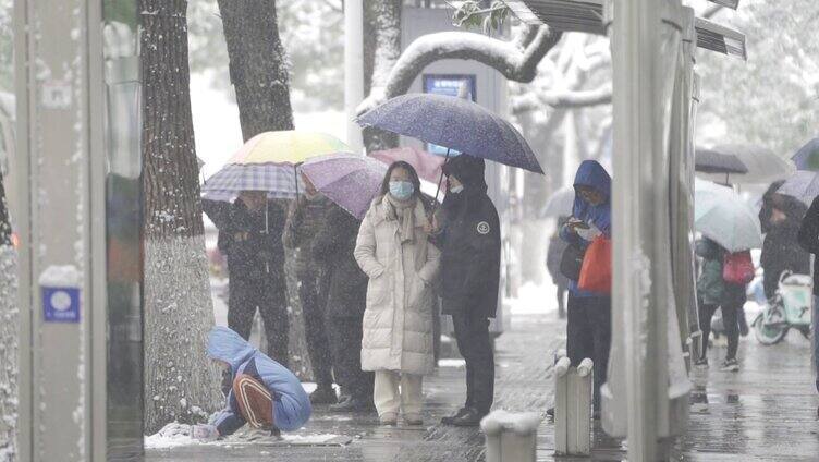 冰雪天气公交站等车的乘客