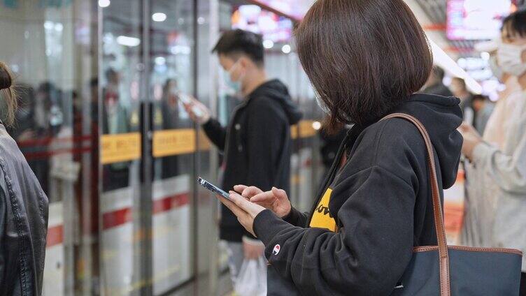 地铁站台低头看手机玩手机的短发女士