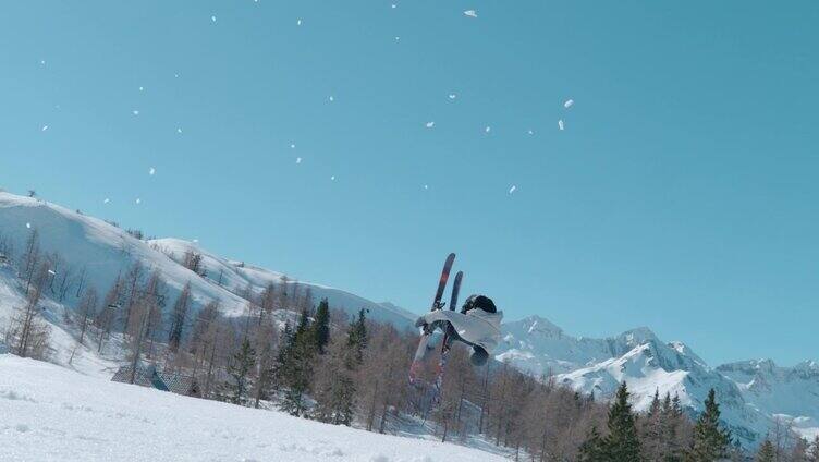 男性滑雪者在雪场的雪地公园跳大空中踢腿