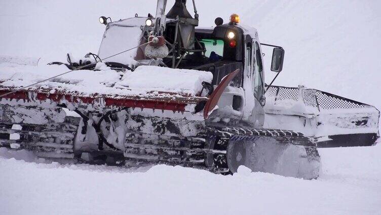 慢镜头:雪地车在滑雪坡上工作