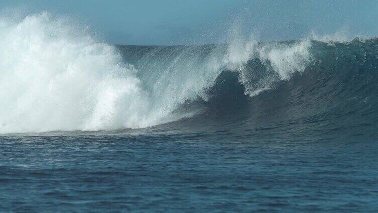 慢动作:巨大的蓝色桶状波浪猛烈地撞击并溅起海水。