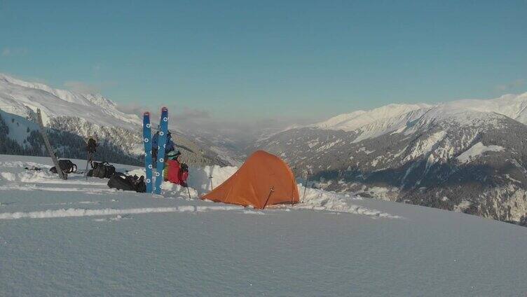 无人机拍摄的一群滑雪者在雪山上的帐篷周围