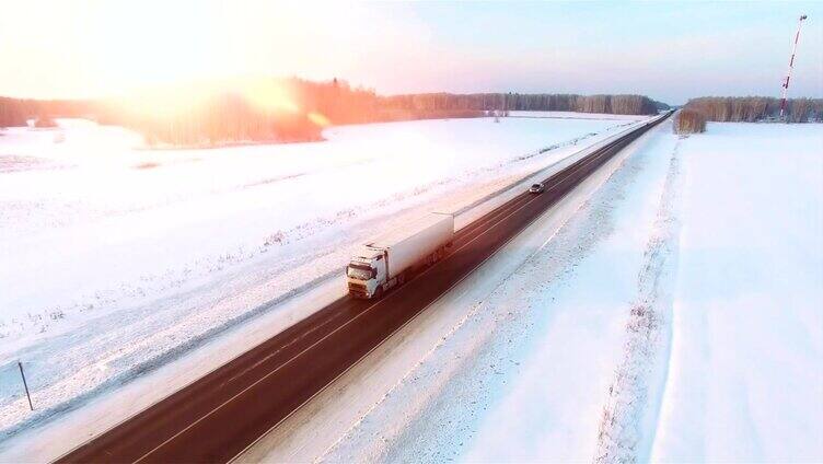 许多卡车在夕阳下行驶在雪地上