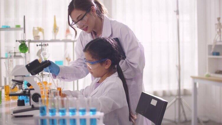 女生在课堂实验室用显微镜进行科学实验