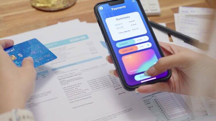 近距离双手妇女使用智能手机支付与非接触式支付和银行应用程序支付在线水电费支付，网上银行技术和资金转移。