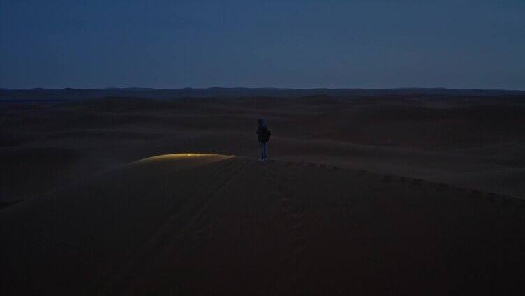 夜晚行走在沙漠的路人