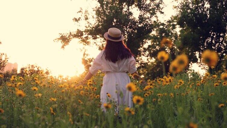 一个年轻女子穿过一片花田