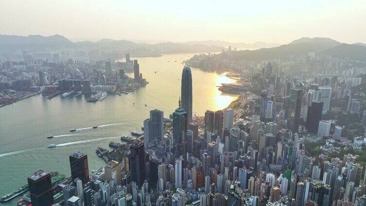 左环绕香港城市建筑金色阳光洒在海面上航拍