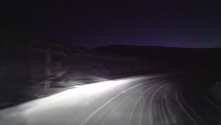 晚上在森林里的雪路上开车