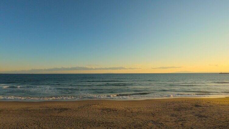 黄昏时沿着海边的路开车。有海岸线海景的人行道。海滩上的人们。