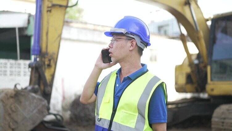 在建筑工地，蓝领工人正在和推土机一起工作。